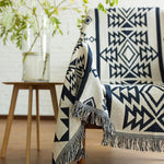 Vendbart boho-plaid i vævet design over sofa