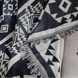 Vendbart boho-plaid i vævet design over sofa