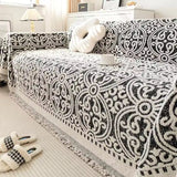 Sofabetræk i jacquard med ornamentmønster og frynsede kanter på sofa