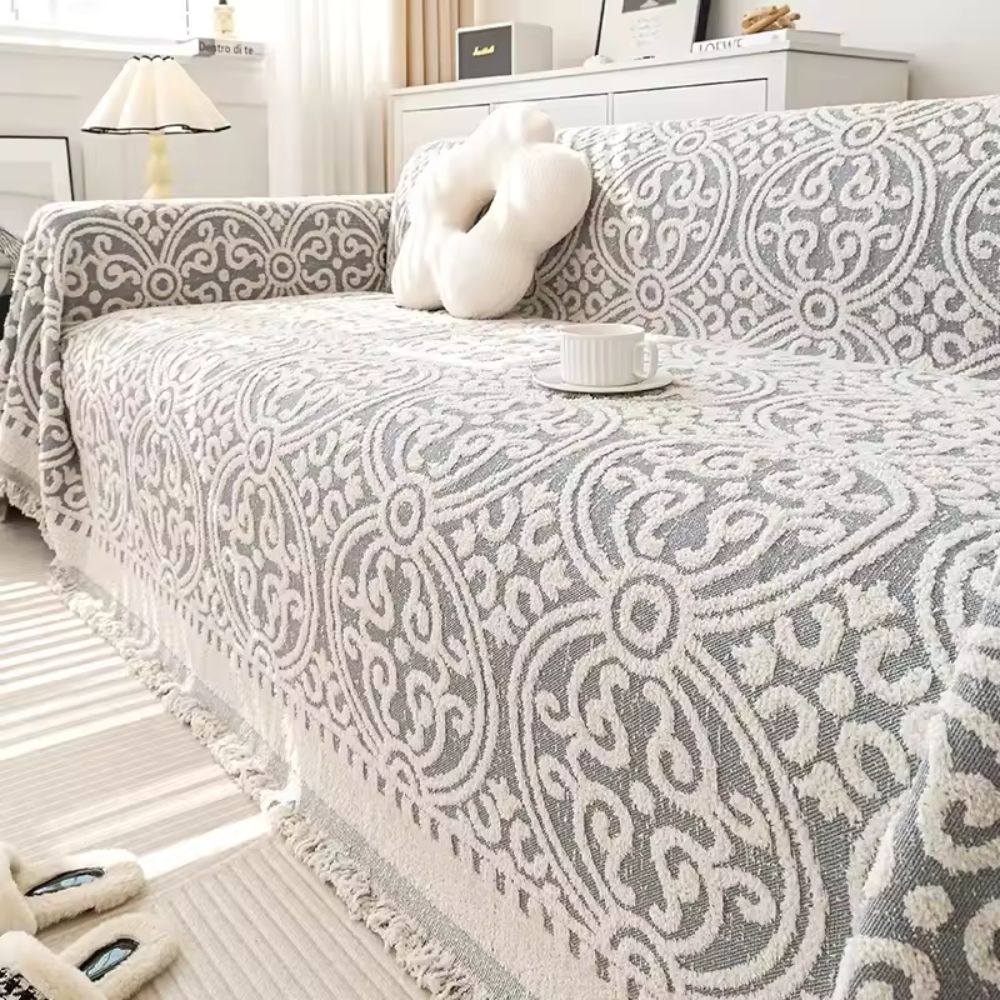 Sofabetræk i jacquard med ornamentmønster og frynsede kanter på sofa