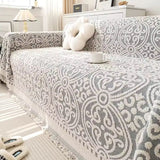 Sofabetræk i jacquard med ornamentmønster og frynsede kanter på sofa