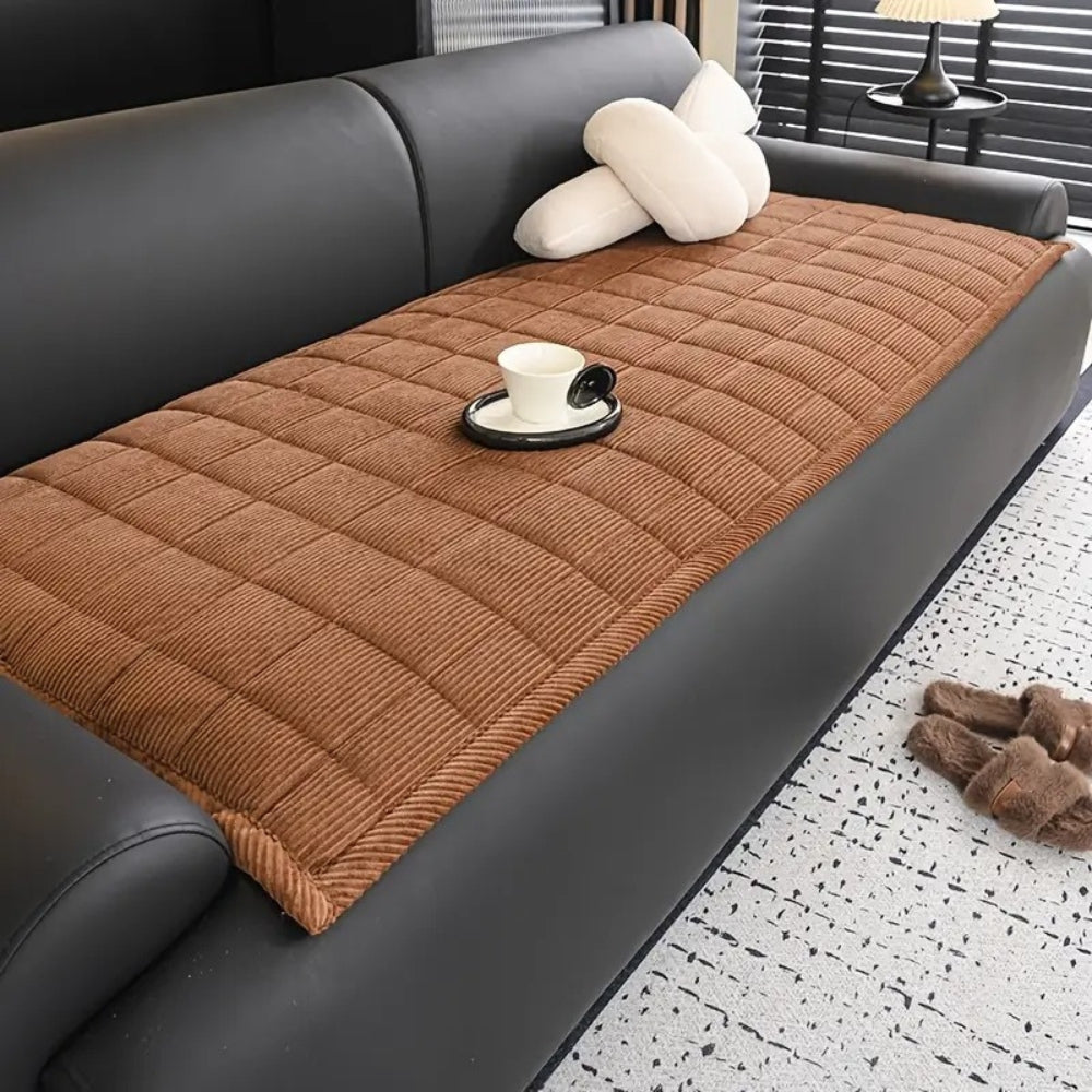 Quiltet sofabetræk i moderne design på sofa i minimalistisk stue