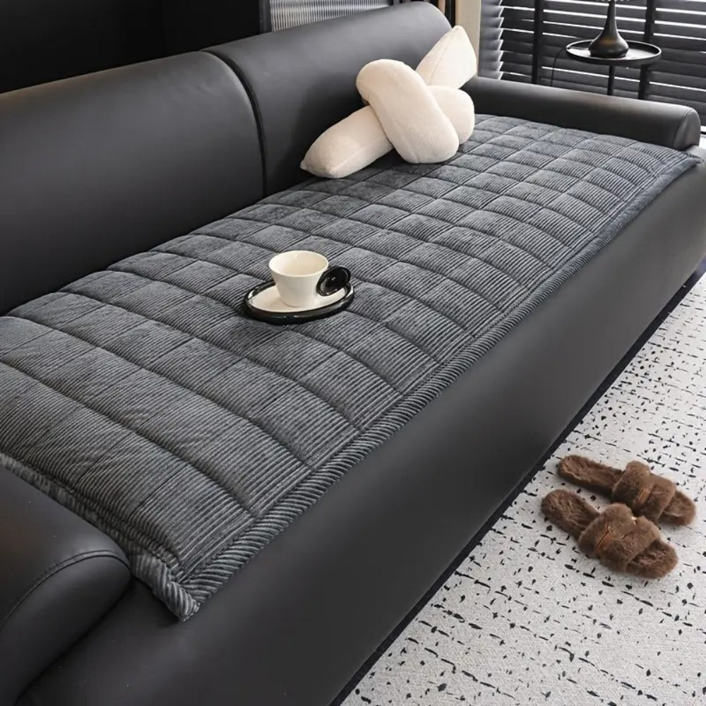 Quiltet sofabetræk i moderne design på sofa i minimalistisk stue
