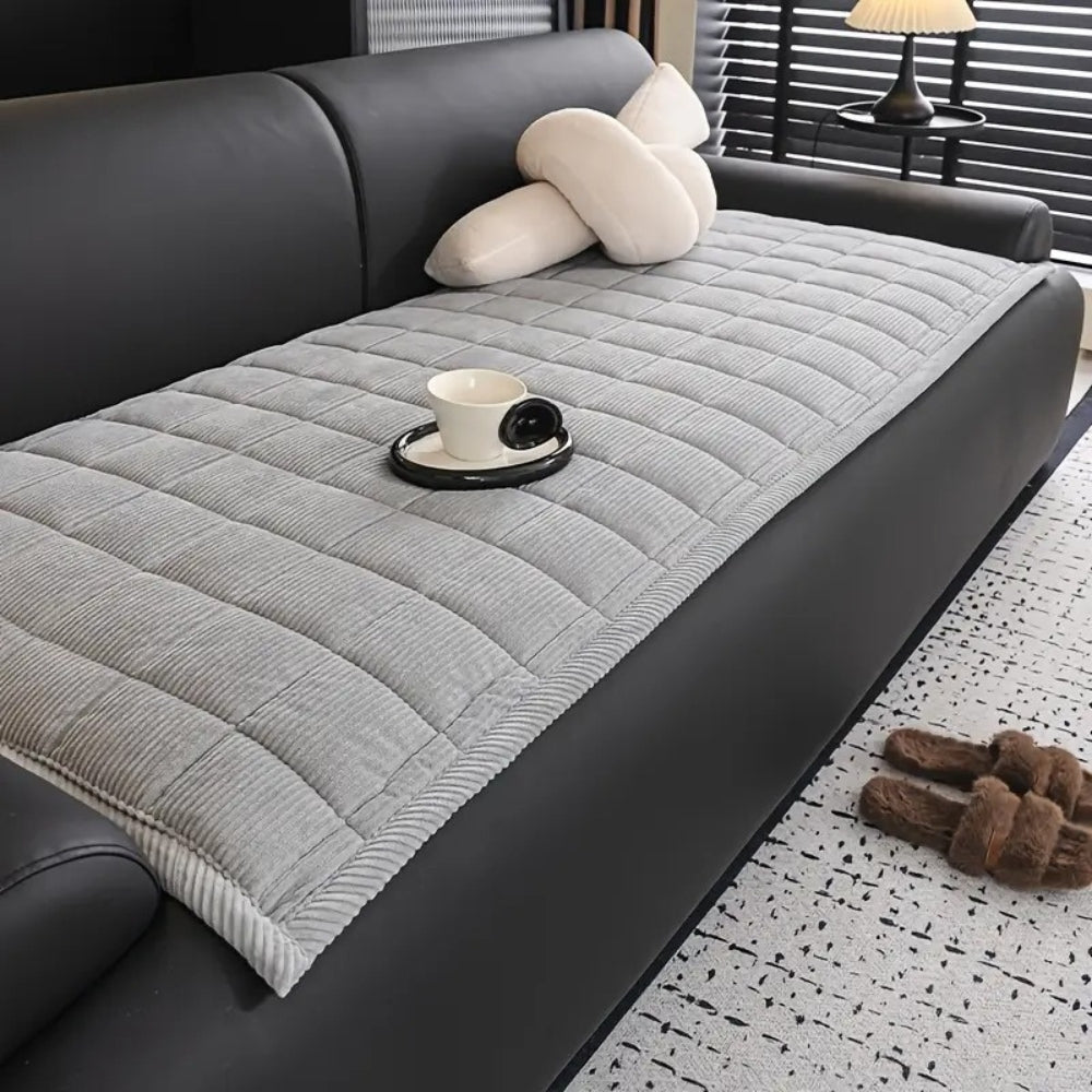 Quiltet sofabetræk i moderne design på sofa i minimalistisk stue