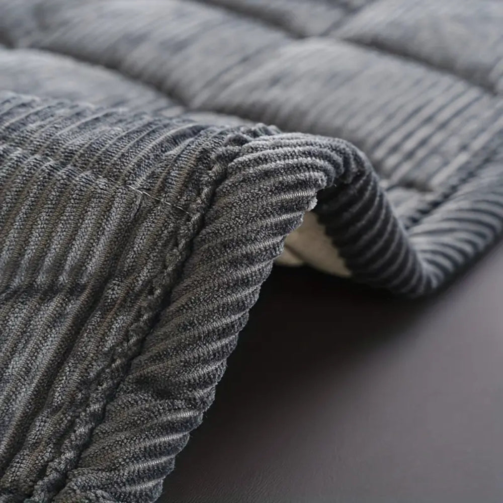 Quiltet sofabetræk i moderne design på sofa i minimalistisk stue