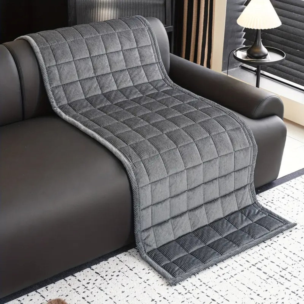 Quiltet sofabetræk i moderne design på sofa i minimalistisk stue