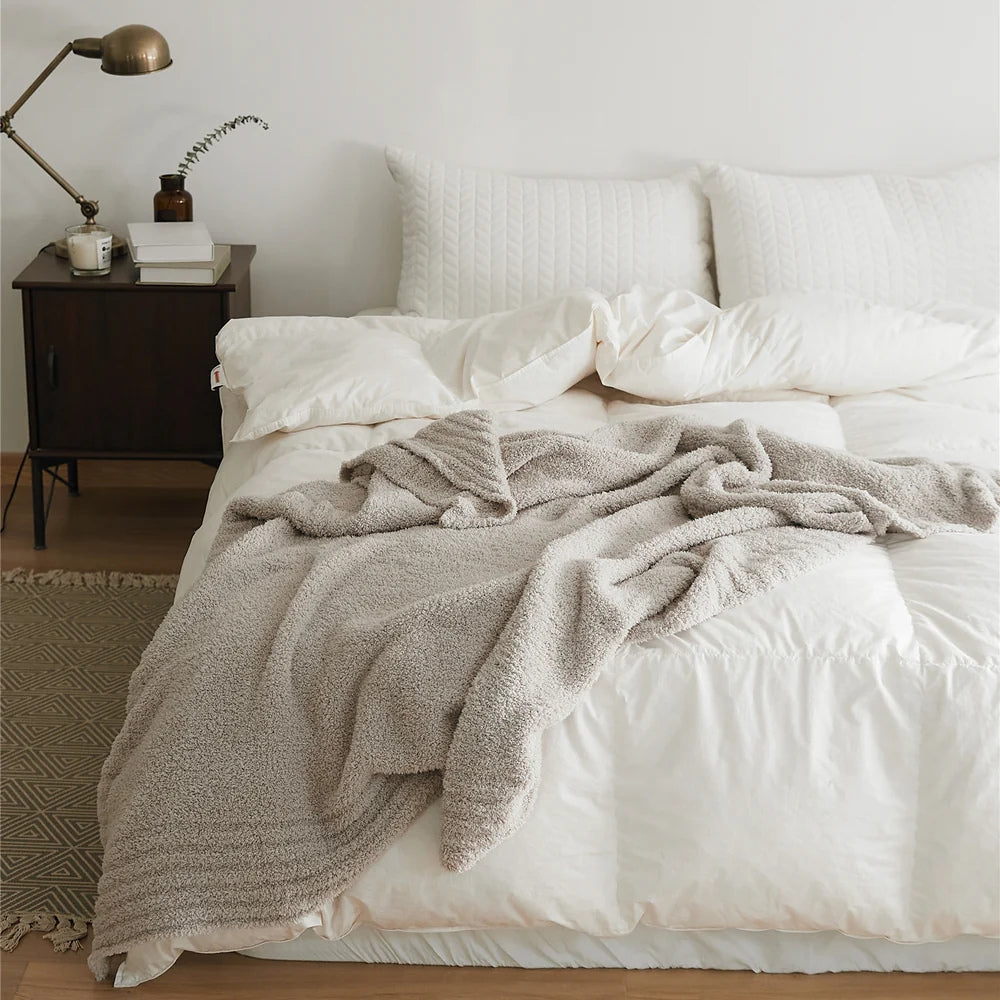 Ensfarvet minimalistisk strikket plaid draperet over sofa