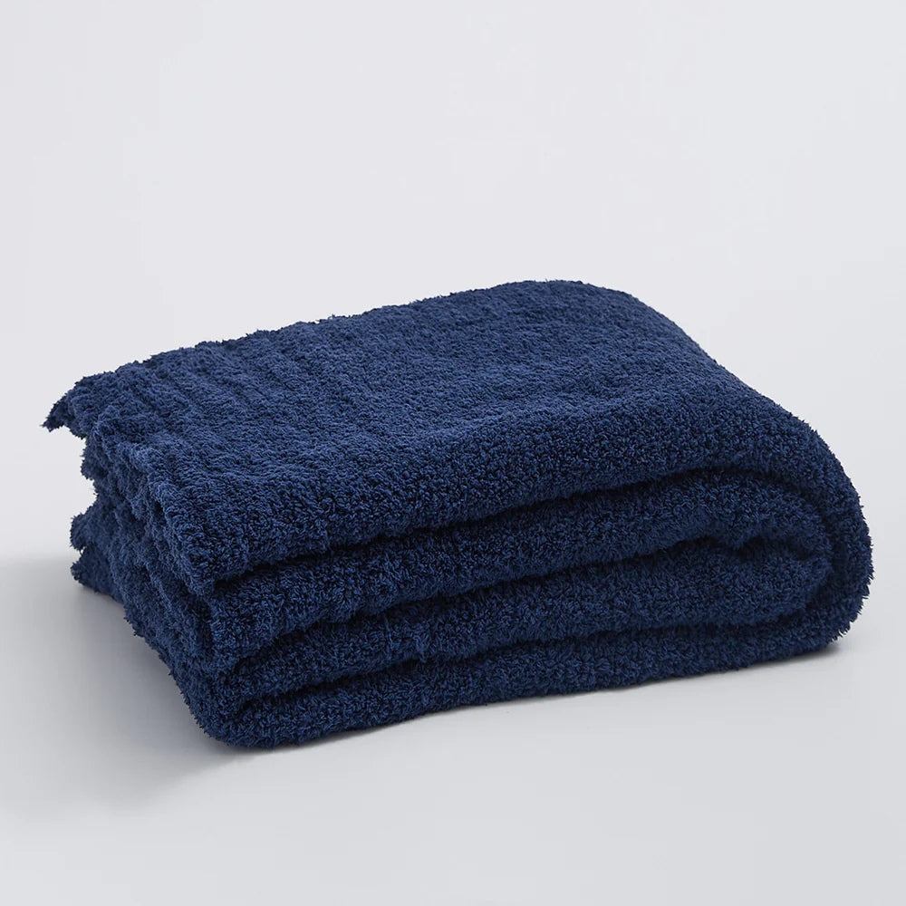Ensfarvet minimalistisk strikket plaid draperet over sofa