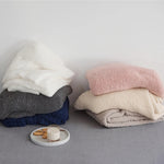 Ensfarvet minimalistisk strikket plaid draperet over sofa