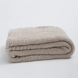 Ensfarvet minimalistisk strikket plaid draperet over sofa
