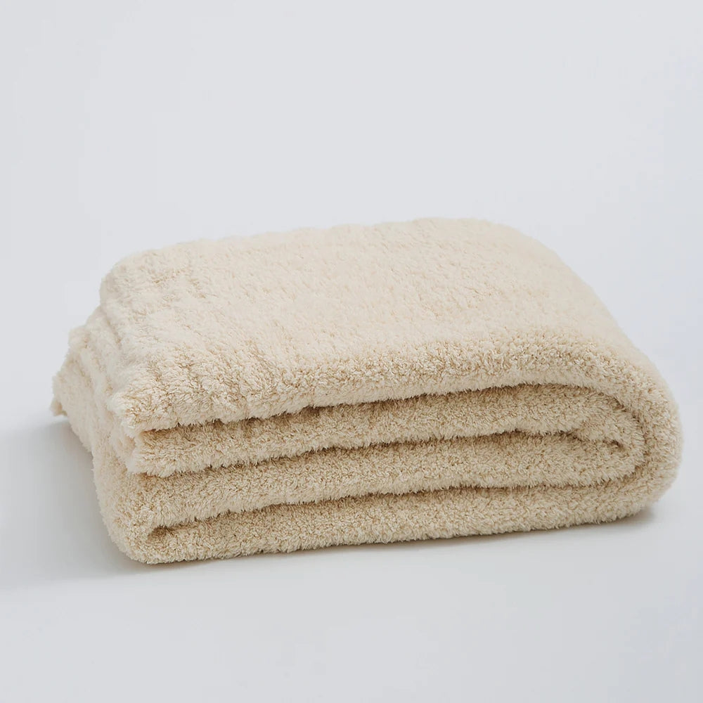 Ensfarvet minimalistisk strikket plaid draperet over sofa