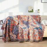 Bomuldsplaid med blomsterjacquard i orange og blå over sofaen