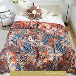 Bomuldsplaid med blomsterjacquard i orange og blå over sofaen