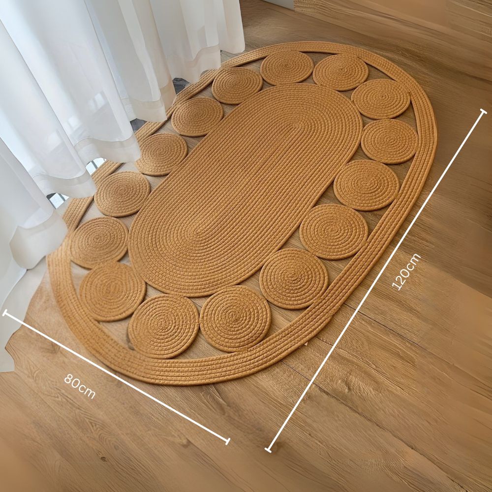 Ovalt boho-tæppe med spiralmønster i neutrale farver på gulvet