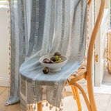 Transparent stribet gardin med kvaster foran vindue i stue