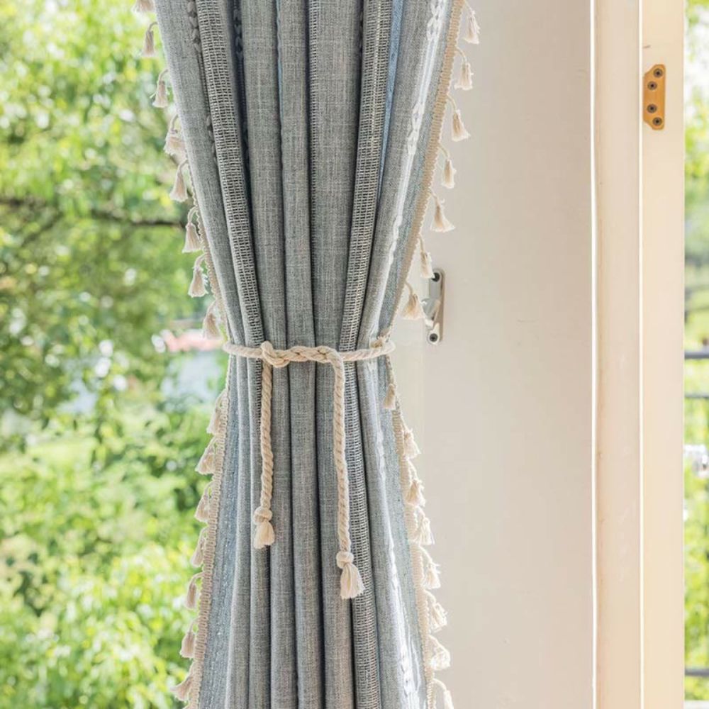 Transparent stribet gardin med kvaster foran vindue i stue