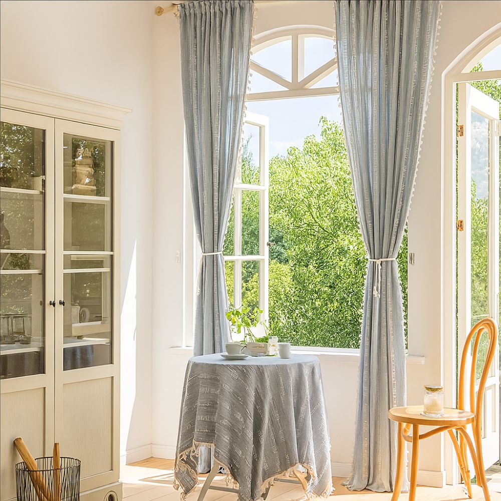 Transparent stribet gardin med kvaster foran vindue i stue