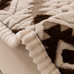 Tykt quiltet sofabetræk i plys på grå sofa