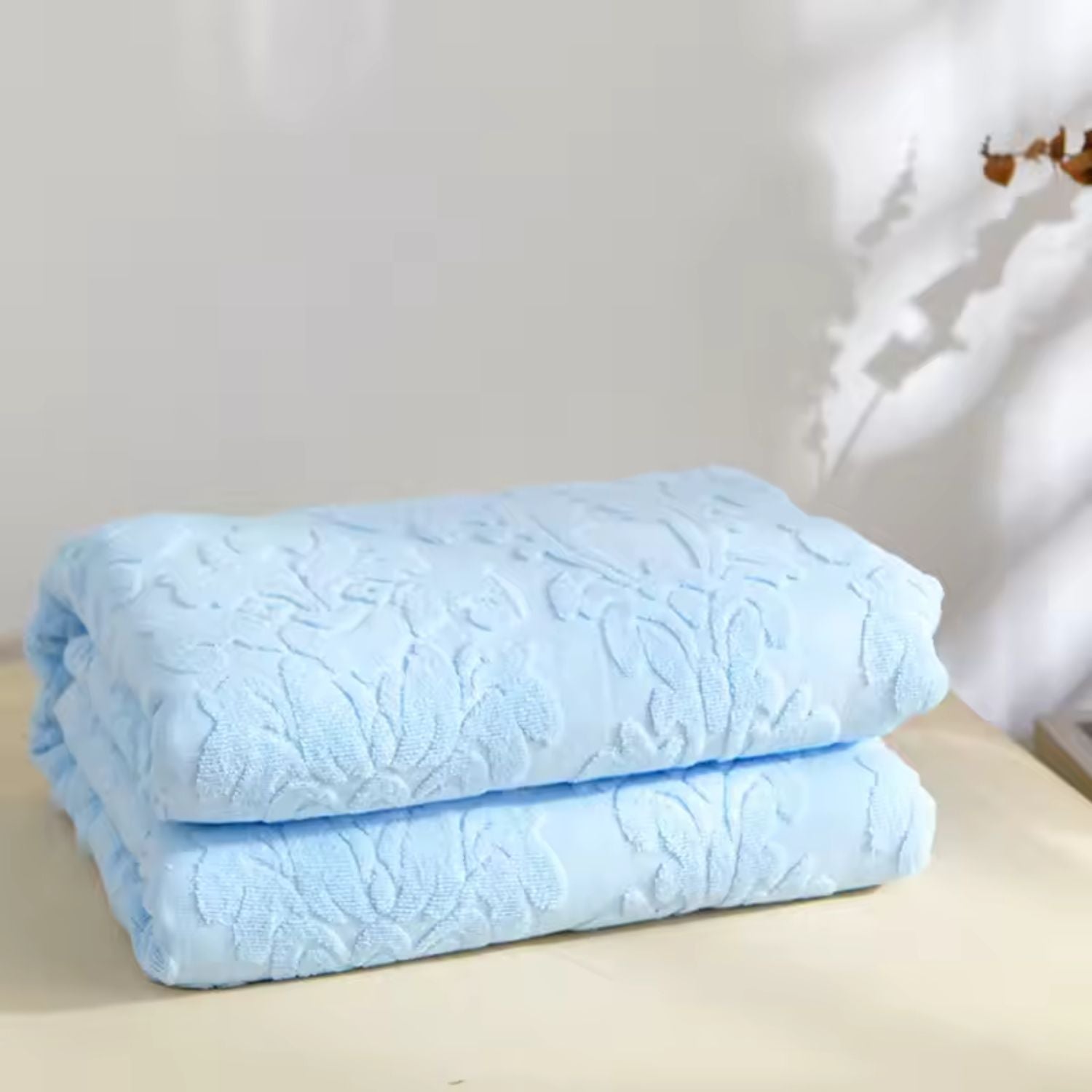 Blød plaid med blomstermønster i jacquard draperet over sofa