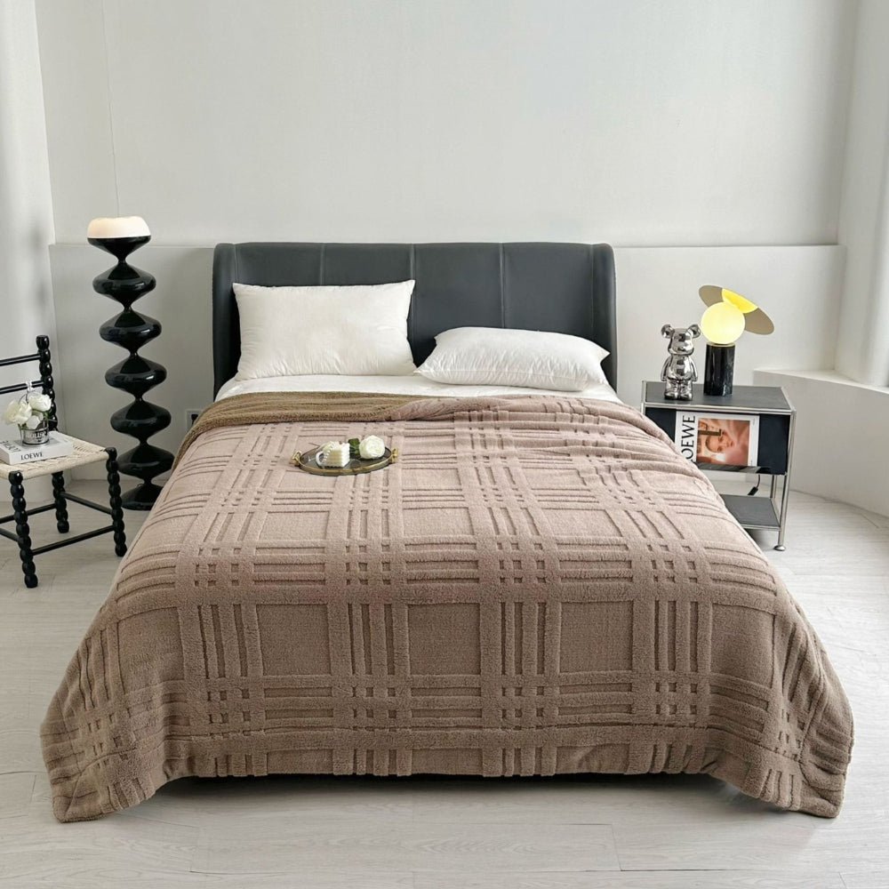 Blødt plaid med præget ternmønster over sofa i stuen