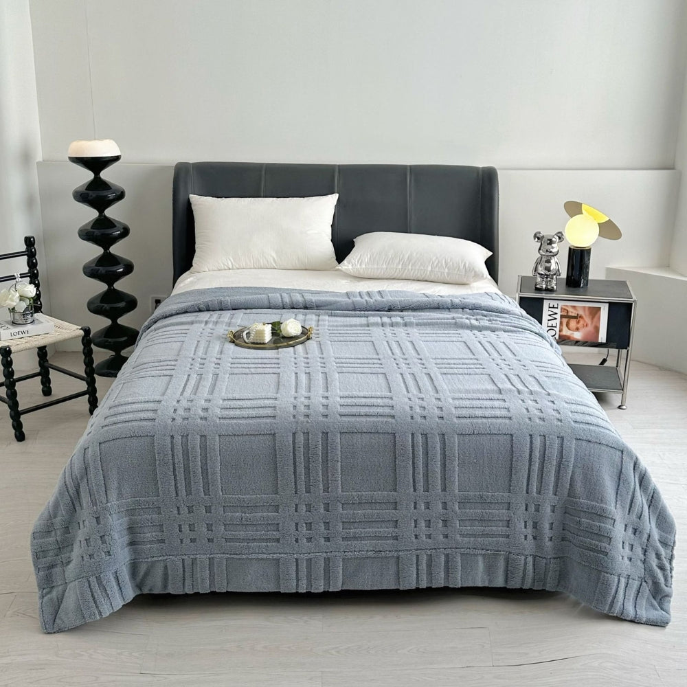 Blødt plaid med præget ternmønster over sofa i stuen