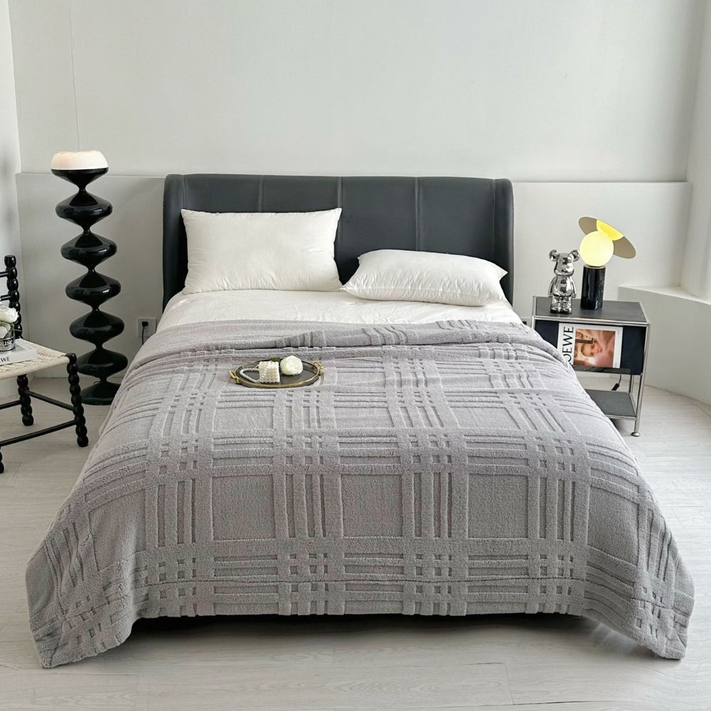 Blødt plaid med præget ternmønster over sofa i stuen