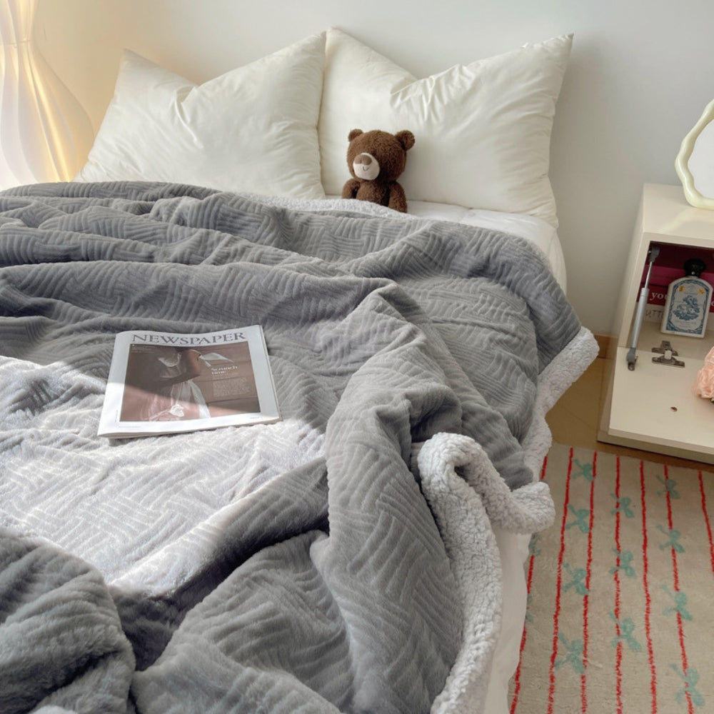 Tykt plaid i blødt kaninplys med jacquardmønster over sofa