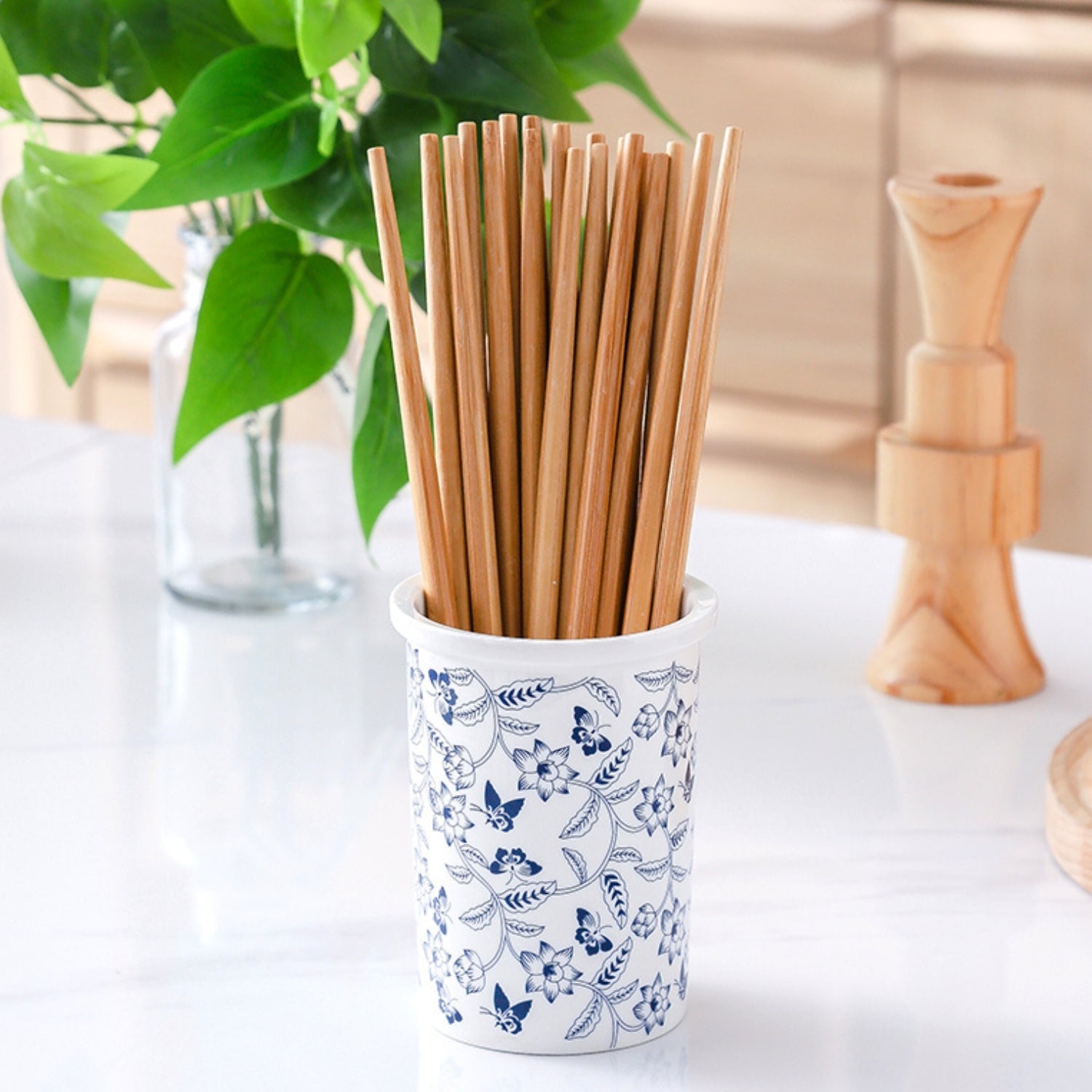 Keramisk redskabsholder med blomsterdesign og tre beholdere i køkken