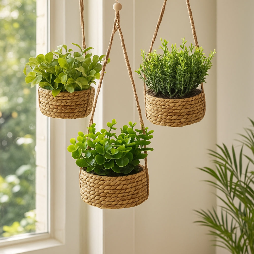 Hængende kunstig plante i vævet kurvepotte på altan