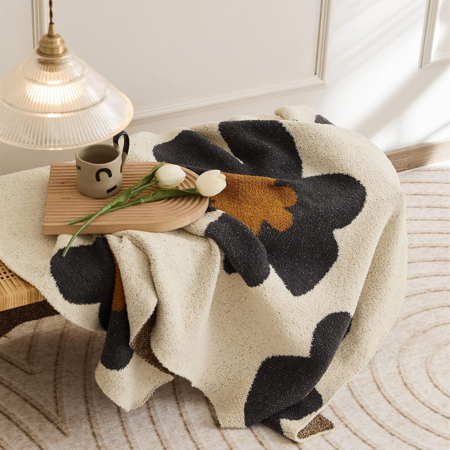 Strikket tæppe med blomstermønster på sofa